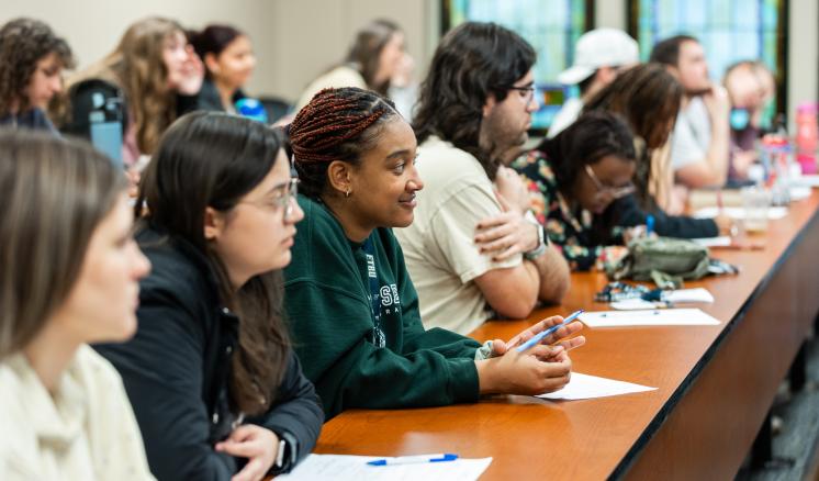 Group of female students sitting in a classroom listening to the speaker 