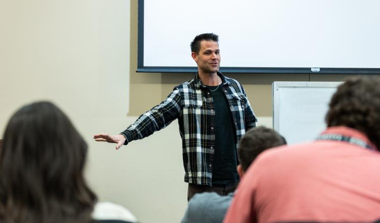 Man talking in front of a group of students 