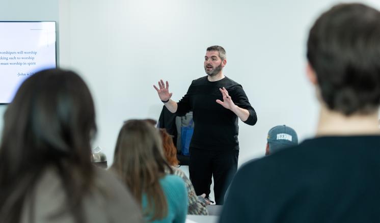 Man talking in front of a group of students 