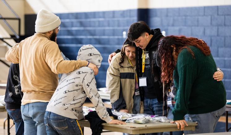 A group of students praying with each other 