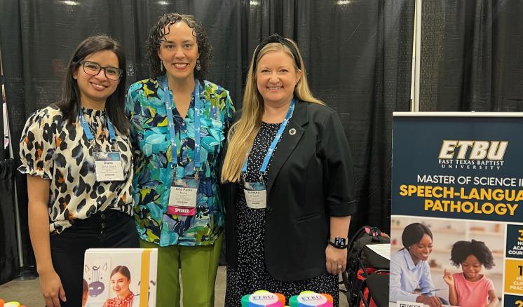 Three women standing at speech booth 