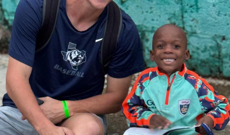 Man sitting next to boy on curb 