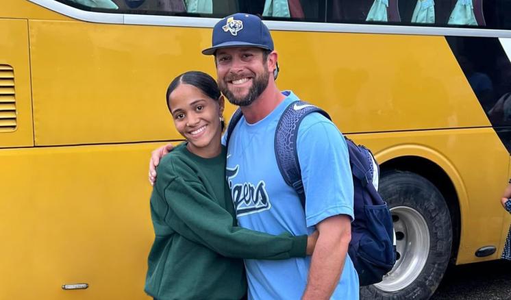 Man and girl smiling at the camera in front of a bus