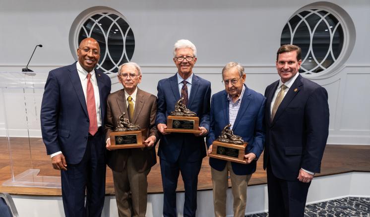 r63_0991 Three men holding awards in the center with two men on either side smiling at the camera