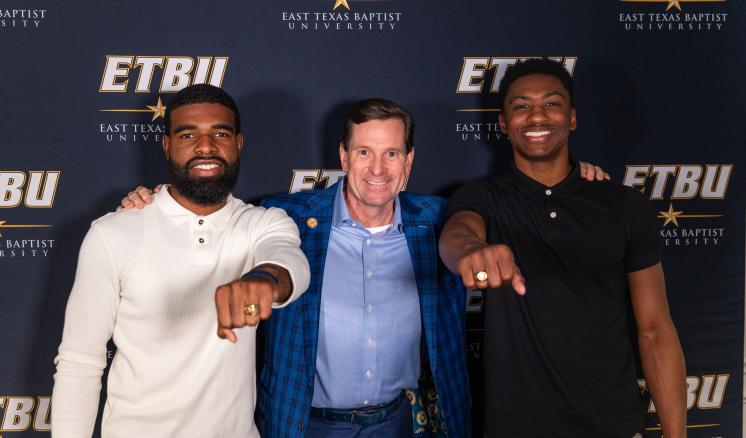Ring Blessing Spring 2024 Two seniors show off their rings with ETBU President Dr. Blair Blackburn at the Ring Blessing Spring 2024 ceremony