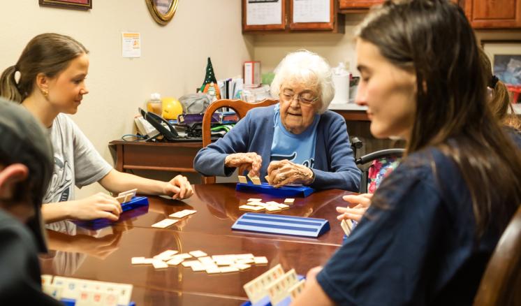 A small group of people seated around a table playing board games