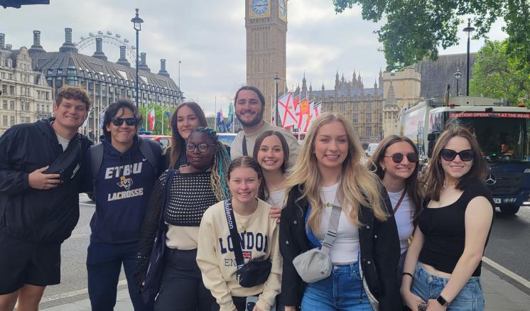 A group of people standing outside together in front of Big Ben in London