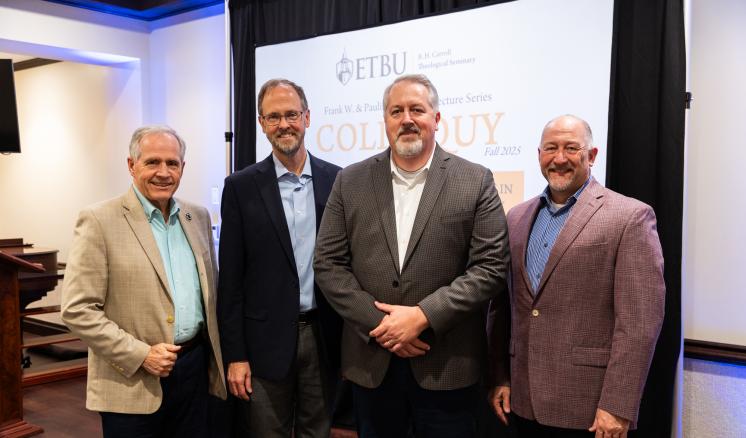 A group of men standing in formal attire together inside