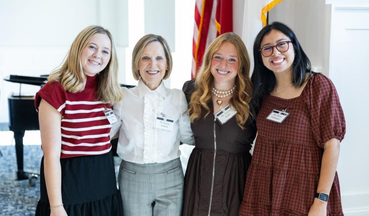 A group of women stood smiling together indoors