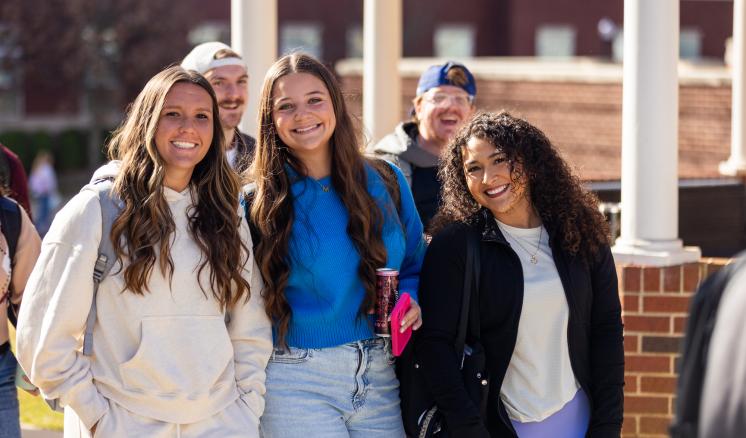 A group of women outside smiling and walking together