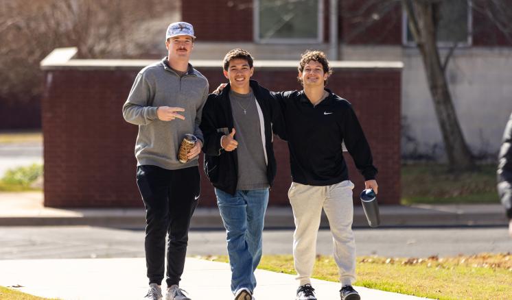 A group of men outside smiling and walking together