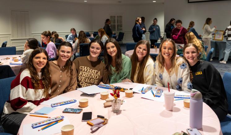 A group of people at a table eating together and smiling