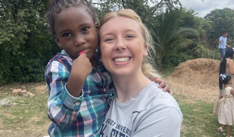 A woman holding a small child smiling