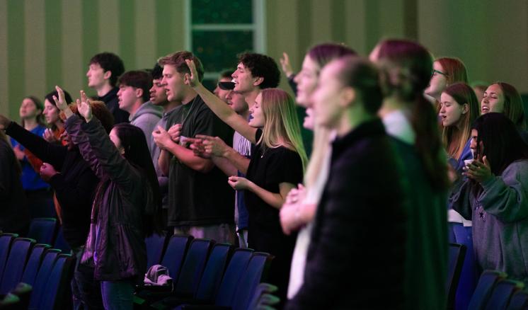A large crowd of people worshipping together