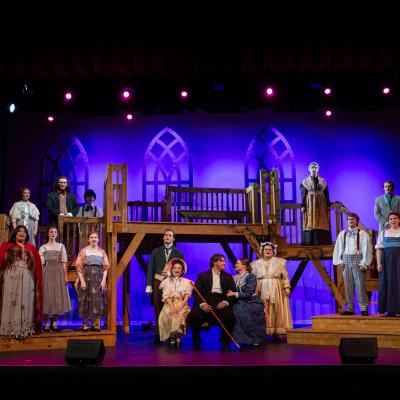 The cast of the Spring 2024 production of Jane Eyre the musical pose for a photo on stage at Memorial City Hall in downtown Marshall, Texas