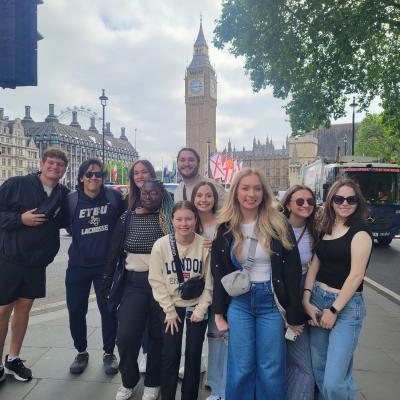 A group of people standing outside together in front of Big Ben in London