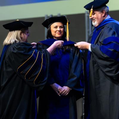 A group of people standing on a stage in academic regalia
