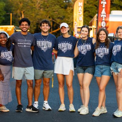 A group of college students standing together outside with ETBU Student Foundation written on their shirts