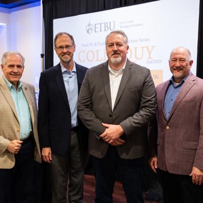 A group of men standing in formal attire together inside