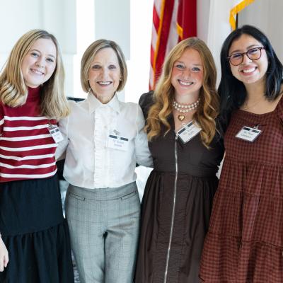 A group of women stood smiling together indoors