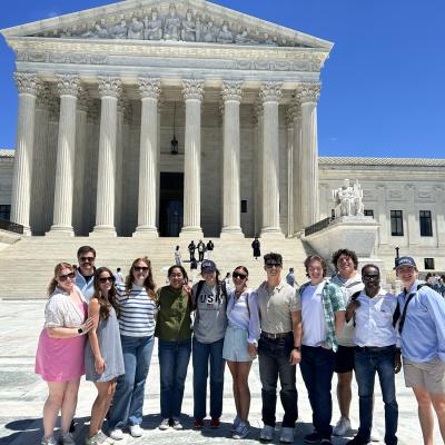 A group of students standing in front of the Supreme Court.