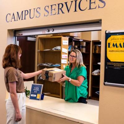 student picking up package in mail room 