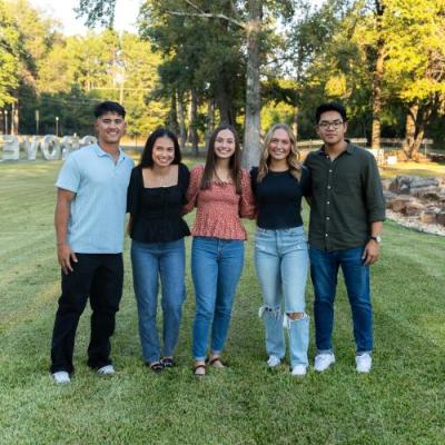 students smiling at camera outside