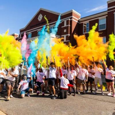 Students throwing color in the air following a color run race.