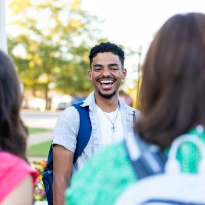 A group of students laughing and talking outside.