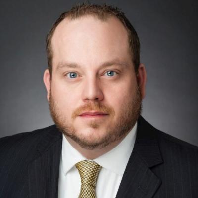 Man with a beard wearing a black suit and white shirt