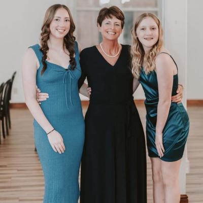 woman standing hugging hre two daughters