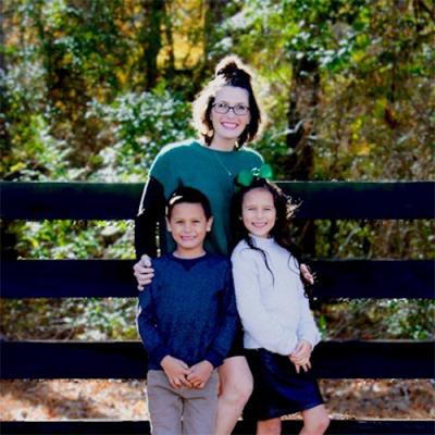 A woman posing with her 2 children outside