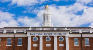 Red brick building with blue sky and white clouds.