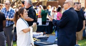 A girl in a white shirt talking to an older man in a navy suit