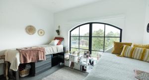 Dorm room interior with white wall and two twin beds.