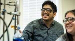 A male students watching a science expirement happen