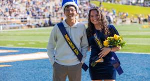 ETBU Homecoming 2025 king and queen outside on a football field in front of stands of people.