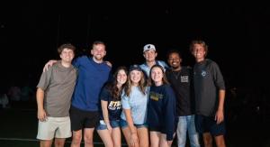 A group of people standing outside underneath fireworks