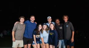 A group of people standing outside underneath fireworks