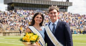 2025 Homecoming King and Queen standing on a football field