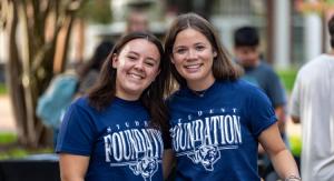 2 women leaning in together for a photo with ETBU clothing