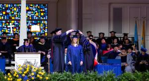 An academic student being "hooded" at commencement for a master's degree