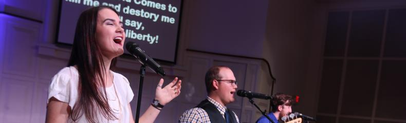 A group of people standing on a stage singing