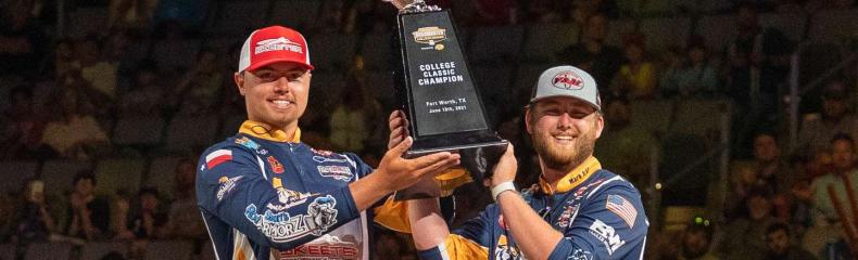 2 men in bass fishing apparrel holding up a trophy