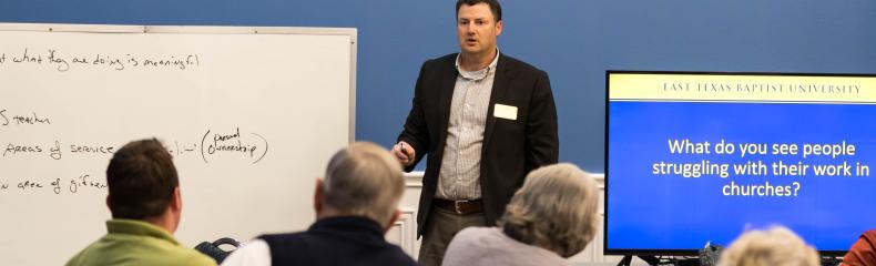 Man speaking to a group of adults