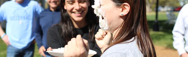 Woman getting pied in the face by another woman