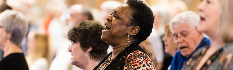 A group of older people singing in a chapel