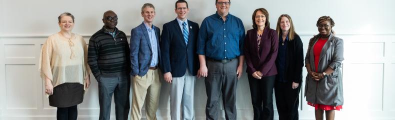 A group of men and women smiling at the camera 