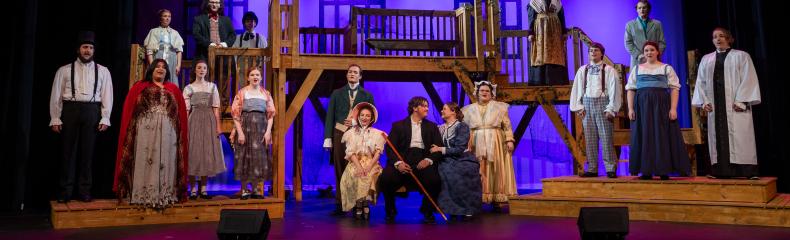 The cast of the Spring 2024 production of Jane Eyre the musical pose for a photo on stage at Memorial City Hall in downtown Marshall, Texas