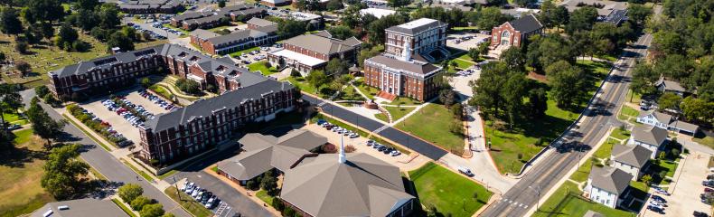 An aerial shot of buildings outdoors shot from the top down on a sunny day
